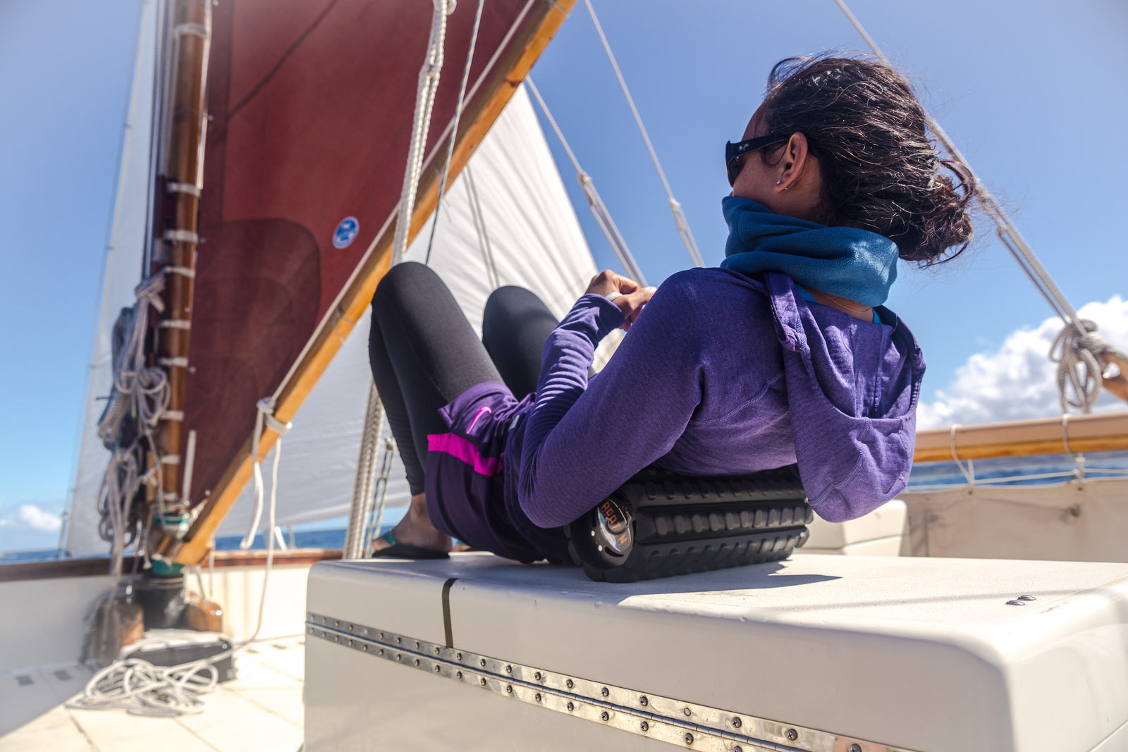 woman using her foam roller on a boat